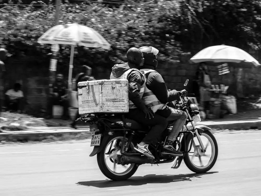 A delivery rider on a motorbike, a package on the back