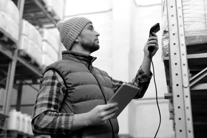 Un magasinier fait l'inventaire avec un lecteur de codes-barres