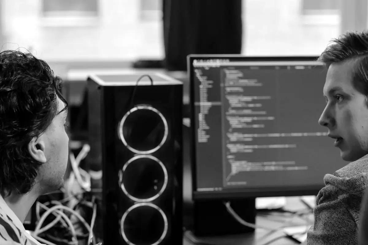 Two developers review code on screen