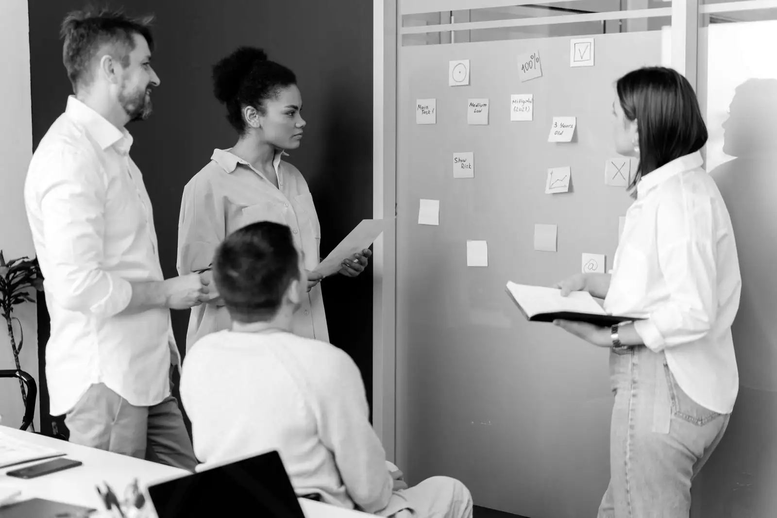 Une équipe note sa façon de travailler sur un tableau couvert de notes